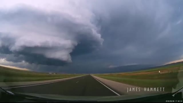 Storm chasing dashcam： Tornado crossing the highway! Laramie, Wyoming