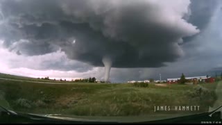 Storm chasing dashcam： Tornado crossing the highway! Laramie, Wyoming